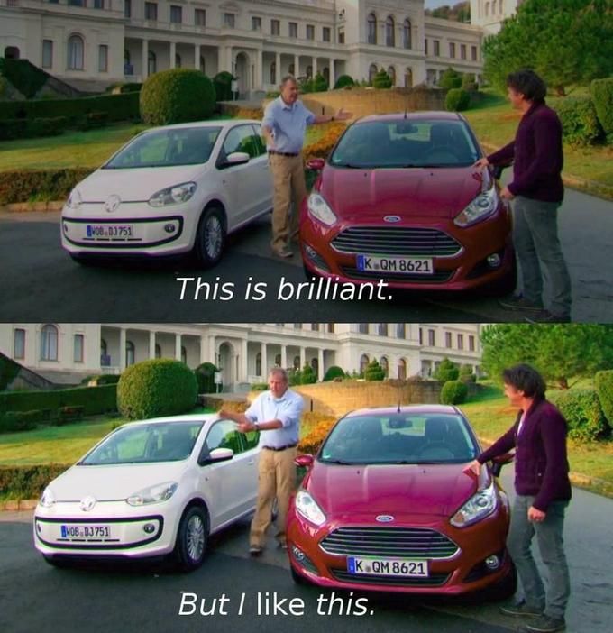A two-panel photo shows two men outdoors between a small white Volkswagen and a red Ford, in front of a large pale building with columns and trimmed round hedges. In the top panel, the gray-haired man in a light blue shirt and beige trousers stands between the cars with his arms open toward the white car, while the dark-haired man in a purple sweater rests a hand on the red car. Centered white text reads “This is brilliant.” In the bottom panel the same men and cars appear, but the gray-haired man now points toward the red car. Centered white text reads “But I like this.”